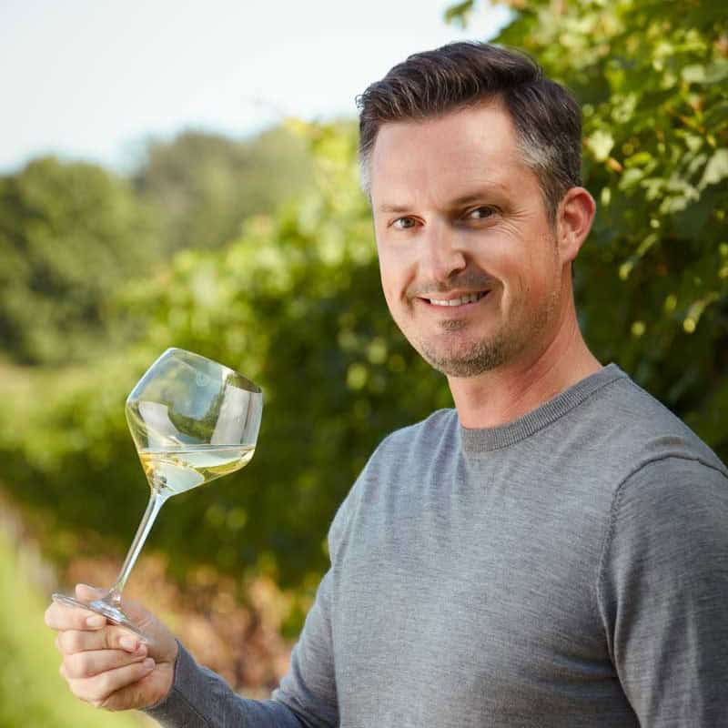 Matt in the vineyard holding a wine glass